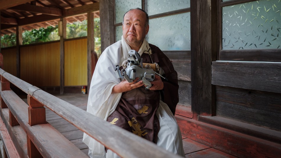 Temple chief priest Bungen Oi holds a Sony pet robot AIBO after a robots' funeral at the Kofukuji temple in Isumi, Chiba on April 26, 2018.