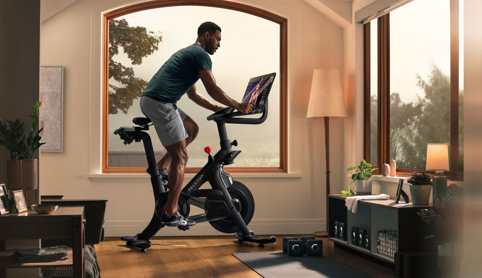 Person riding Peloton bike plus, living room