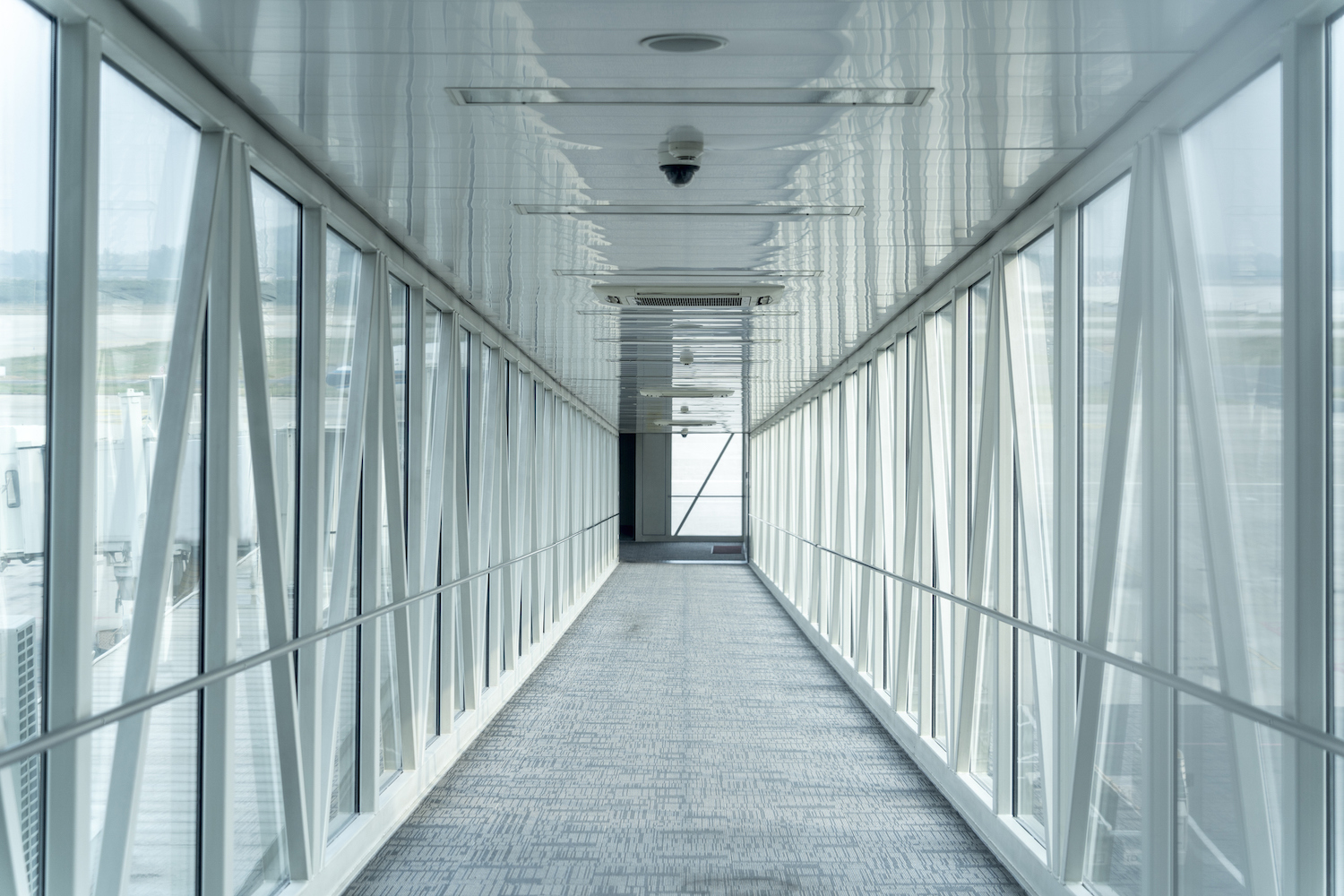 a perspective shot looking down the corridor of a jetway at an airport